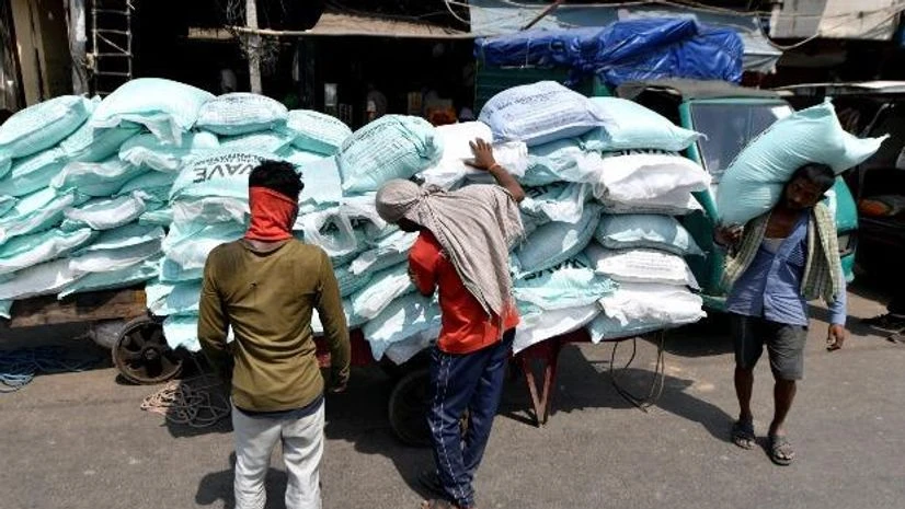 lockdown, coronavirus, Labour Day, Workers Workers load filled sacks on a cart at Shardhanand Market during the nationwide lockdown, near GB Road in New Delhi