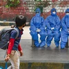 A young boy walks past medics waiting to check the temperature of passengers at Majestic bus stand in Bengaluru. Photo: PTI