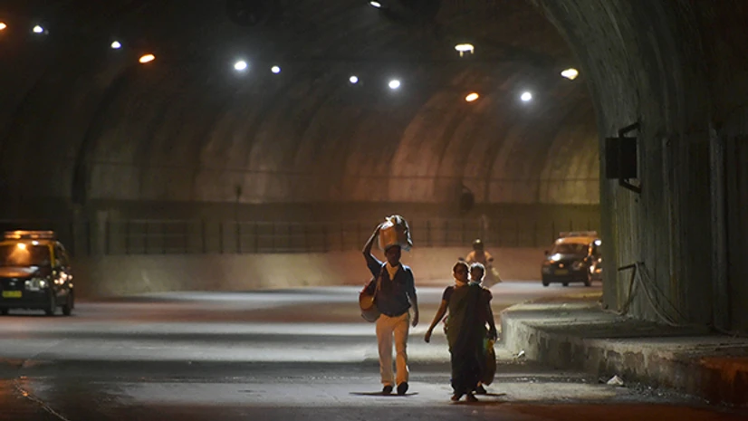 migrant workers, lockdown 3.0, Covid-19, Coronavirus, labourers. Migrants from Raigad district of Maharashtra walk through a tunnel along the easter freeway, in Mumbai. Photo: PTI