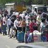 People wait to enter New Delhi Railway Station following resumption of passenger train services connecting major cities