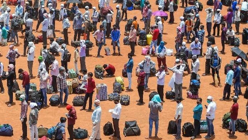 migrant workers, lockdown, Covid-19, Coronavirus, labourers. Migrants waiting in queues to board buses departing for railway terminus, from where they will board trains to travel to their native places, during the ongoing nationwide Covid-19 lockdown, at Wadala in Mumbai. Photo: PTI
