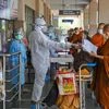 A security man wearing a protective suit checks documents of stranded Buddhist monks from Thailand at Gaya airport, during the ongoing Covid-19 lockdown, in Gaya. Photo: PTI