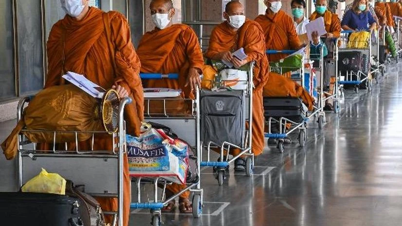 Covid-19, coronavirus, airport checking, lockdown, stranded monks, passengers Stranded Buddhist monks stand in a queue to board a special flight for Bangkok at Gaya airport, during the ongoing Covid-19 lockdown, in Gaya. Photo: PTI