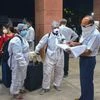 A railway official checks documents of passengers before boarding a train at a railway station following the resumption of passenger train services by the Indian Railways in a graded manner, in Bhopal. Photo: PTI