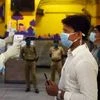 Health workers conduct thermal screening of passengers who have arrived from Delhi by a special train at Howrah station, during the ongoing COVID-19 nationwide lockdown, in Kolkata