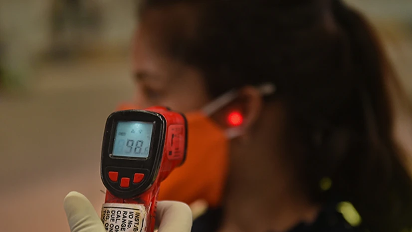 Lockdown4.0, coronavirus testing, Covid-19 testing, medics A medic conducts thermal screening of a passenger waiting to board a train to Delhi at Howrah station, during the ongoing Covid-19 nationwide lockdown, in Kolkata. Photo: PTI