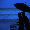 People watch as waves crash along the shore ahead of cyclone 'Amphan' landfall, in Balasore district. Photo: PTI