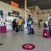 Passengers respecting social distancing norms stand outside a counter at the Prayagraj Airport, following the resumption of domestic flights