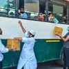 Clerics distribute fruits and water bottles among migrants sitting in a bus to reach their native places, during the ongoing COVID-19 lockdown, in Moradabad