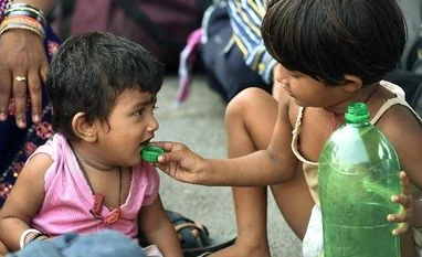 India coronavirus dispatch: Can 'social bubbles' contain Covid-19 spread? A migrant child feeds water to a toddler while waiting with their family to board a train at Central Railway station, during the ongoing nationwide COVID-19 lockdown, in Chennai