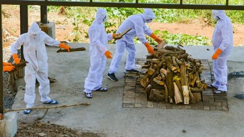 lockdown, coronavirus victim, cremation Municipal workers wearing protective suits cremate the body of COVID-19 victim, in Karad