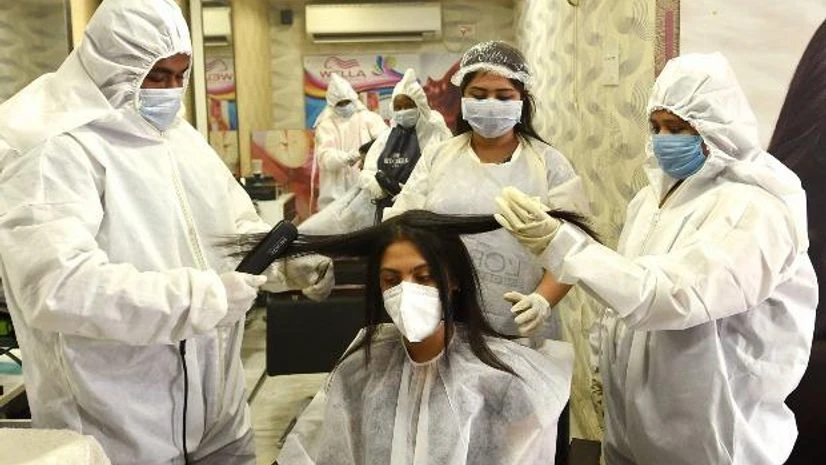 lockdown, coronavirus, parlour Beauticians wearing PPE kits attend a customer at a parlour that was opened during the fourth phase of COVID-19 lockdown, in Kolkata