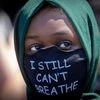 A person wears a mask with a message at the Minneapolis corner where George Floyd was restrained by Minneapolis police