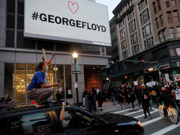 Les passagers d'une voiture acclament les manifestants qui s'élèvent contre la mort de George Floyd, détenu par la police de Minneapolis, sous un panneau d'affichage portant son nom, à Boston, Massachusetts Les passagers d'une voiture acclament les manifestants qui s'élèvent contre la mort de George Floyd, détenu par la police de Minneapolis, sous un panneau d'affichage portant son nom, à Boston, Massachusetts