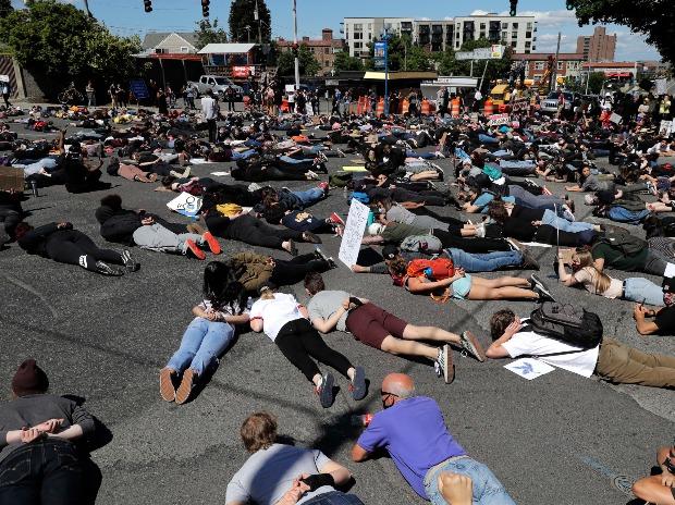 Des personnes bloquent la circulation alors qu'elles sont allongées face contre terre dans la rue à un carrefour de Tacoma, dans l'État du Washington, pendant 8 minutes et 46 secondes, lors d'une manifestation contre la brutalité policière Des personnes bloquent la circulation alors qu'elles sont allongées face contre terre dans la rue à un carrefour de Tacoma, dans l'État du Washington, pendant 8 minutes et 46 secondes, lors d'une manifestation contre la brutalité policière