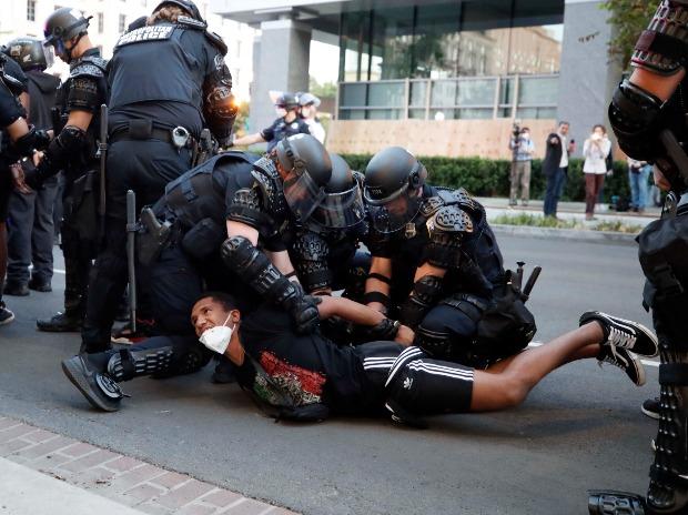 Un manifestant est arrêté par la police après l'instauration d'un couvre-feu lors d'une manifestation contre la mort de George Floyd Un manifestant est arrêté par la police après l'instauration d'un couvre-feu lors d'une manifestation contre la mort de George Floyd