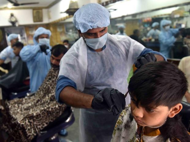 A hair-stylist wearing protective suit attends to a customer at a Oriental hair Cutting Salon that opened after a gap of three months owing to Covid-19 pandemic at Dhobitalao in Mumbai A hair-stylist wearing protective suit attends to a customer at a Oriental hair Cutting Salon that opened after a gap of three months owing to Covid-19 pandemic at Dhobitalao in Mumbai