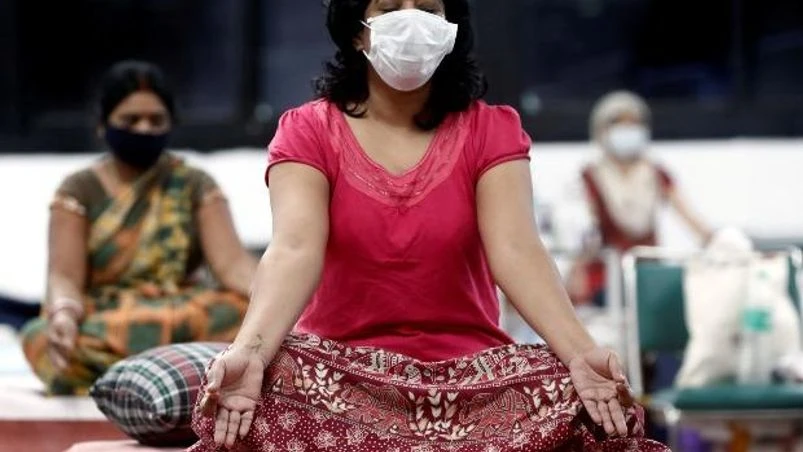 coronavirus People suffering from the coronavirus disease perform yoga inside a care centre for patients at an indoor sports complex in New Delhi