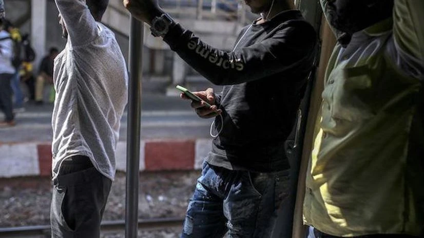 Telecom, cellphone, train, Passengers standing in a local train | Photo: Bloomberg