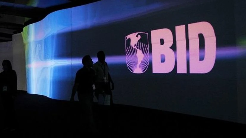 Banco Interamericano de Desarrollo, BID, Inter-American Development Bank Visitors walk past a screen with the logo of Banco Interamericano de Desarrollo (BID), also known as the Inter-American Development Bank, at the Atlapa Convention Center. Photo: Reuters
