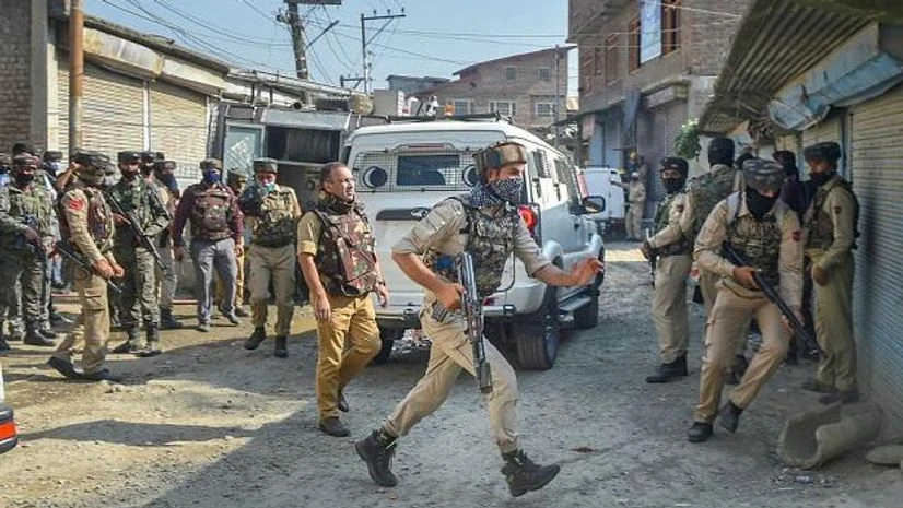 Indian Army, Srinagar, Jammu, Kashmir, Batamaloo Security personnel take position during an encounter with militants, at Batamaloo in Srinagar. Photo: PTI