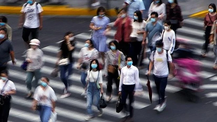 China, Shanghai, asia People wearing face masks walk on a street in Shanghai, following the coronavirus disease outbreak, China. Photo: Reuters