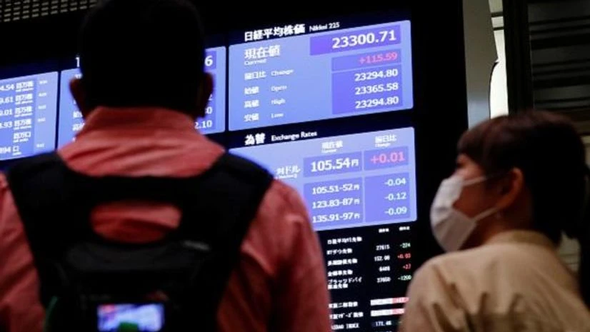 Tokyo Stock Exchange, TSE TV crews talk in front of a large screen showing stock prices at the Tokyo Stock Exchange in Tokyo. Photo: Reuters