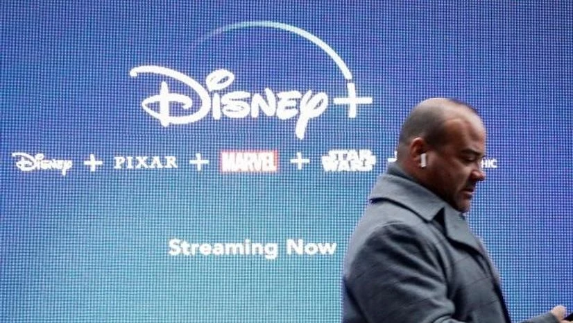 Disney A man looks at his phone as he passes by a screen advertising Walt Disney's streaming service Disney in New York City. Photo: Reuters