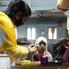 Teachers help a student get ready before the start of an online lecture on a mobile phone inside a digital mobile education library in Mumbai. Photo: Reuters
