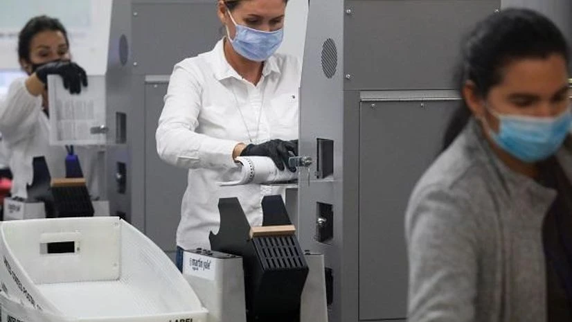 US elections Workers of the Miami-Dade County Elections Department feed mail-in ballots in counting machines during the 2020 US presidential election in Miami, Florida. Photo: Reuters