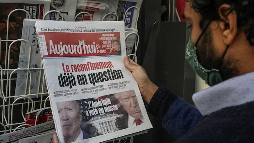 US Elections, Elections, A man wearing a face mask as a precaution against the coronavirus reads the headlines about the U.S. presidential elections at a newspapers stand in Paris, Wednesday, Nov. 4, 2020 | (AP Photo/Michel Euler)