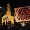 A demonstrator holds up a sign while waiting for election results at Black Lives Matter Plaza, Tuesday, Nov. 3, 2020, in Washington. (AP Photo/John Minchillo)