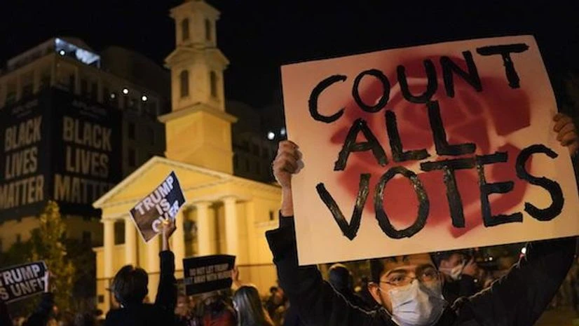 US Elections, Elections, A demonstrator holds up a sign while waiting for election results at Black Lives Matter Plaza, Tuesday, Nov. 3, 2020, in Washington. (AP Photo/John Minchillo)