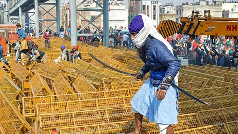 Gantantra Day Parade, farmers rally, farmers parade A farmer walks over the police barricades set up on a road at Akshardham to stop farmers during their during the Kisan Gantantra Parade amid the 72nd Republic Day celebrations, in New Delhi. Photo: PTI
