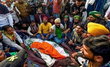 Letter to CJI urges him to take cognizance of violence during tractor rally Farmers near the mortal remains of a protestor, who died after his tractor overturned during their tractor march at ITO on Republic Day, in New Delhi, Tuesday, Jan. 26, 2021. (PTI Photo/Kamal Singh)