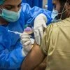 A health worker administers a dose of the Sinopharm Group Co. Covid-19 vaccine to a colleague in Karachi. Photo: Bloomberg