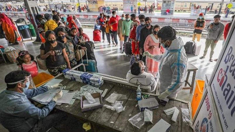 Coronavirus testing A medic takes swab samples from passengers for COVID-19 tests, at Jammu Railway station
