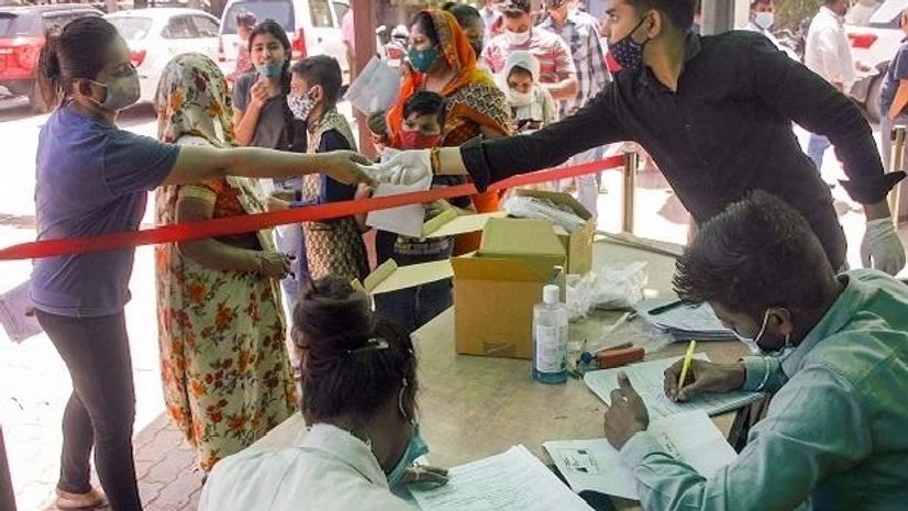 coronavirus, Covid-19 Noida People wait to collect Covid-19 testing kits outside a District Hospital, in Noida | Photo: PTI