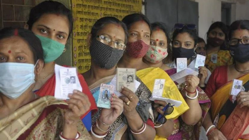 wb polls Women show their voter ID card, as they stand in a queue to cast their vote at a polling station during the 5th phase of West Bengal State Assembly polls, amid surge in Covid-19 cases across the country, at Ranaghat, Nadia (Photo: PTI)