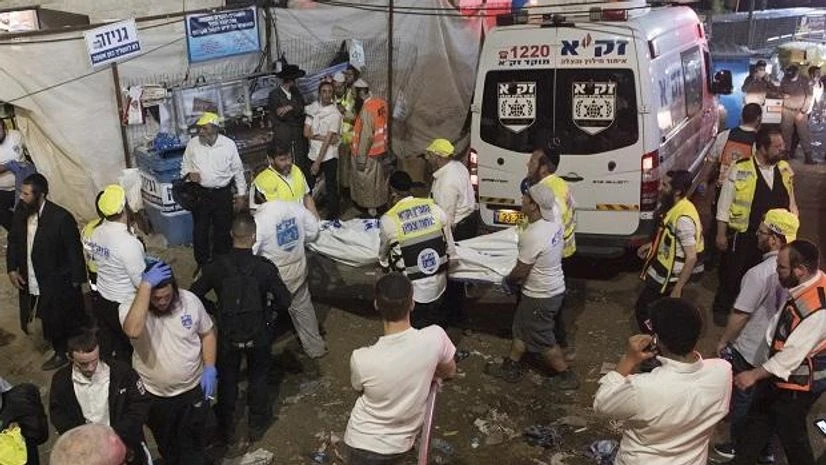 Israeli security officials and rescuers carry a body of a victim who died during a Lag Ba'Omer celebrations at Mt. Meron in northern Israel, Friday, April 30, 2021 Photo: AP Israel, Stampede, Lag Ba'Omer