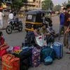 People sit outside Pune railway station during lockdown restrictions imposed by the state government in Pune, Maharashtra, India, on Thursday, May 6, 2021. Serum, the worlds largest vaccine maker based in Pune, will deliver 220 million doses to India