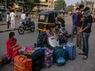 Poverty, Coronavirus People sit outside Pune railway station during lockdown restrictions imposed by the state government in Pune, Maharashtra, India, on Thursday, May 6, 2021. Serum, the worlds largest vaccine maker based in Pune, will deliver 220 million doses to India
