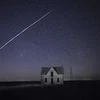 In this photo taken May 6, 2021, with a long exposure, a string of SpaceX StarLink satellites passes over an old stone house near Florence, Kan. The train of lights was actually a series of relatively low-flying satellites launched by Elon Musk's Spa