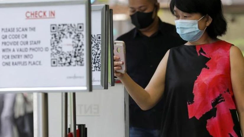 singapore Office workers scan a Safe Entry QR code to enter a mall, amid the coronavirus disease (COVID-19) outbreak in Singapore