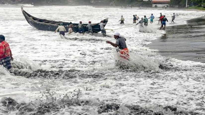 cyclone kerala People pull a boat ashore, which sailed away amid strong winds, after a red alert in view of a cylonic formation in the Arabian Sea, in Thiruvananthapuram (Photo: PTI)