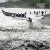 People pull a boat ashore, which sailed away amid strong winds, after a red alert in view of a cylonic formation in the Arabian Sea, in Thiruvananthapuram, Friday, May 14, 2021.