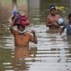 Sri Lankans wade through an inundated street following heavy rainfall at Malwana, on the outskirts of Colombo (Photo: AP/PTI)
