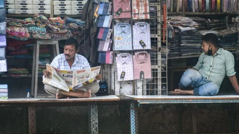 mumbai rains Shopkeepers sit in their shops on a waterlogged street at Hindmata in Mumbai (Photo: PTI)