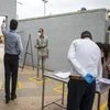 Employees observe social distancing markers as they wait for entrance checks at the HCL Technologies Ltd. Jigani campus in Bengaluru, India, in May 2020. (Photo: Bloomberg)