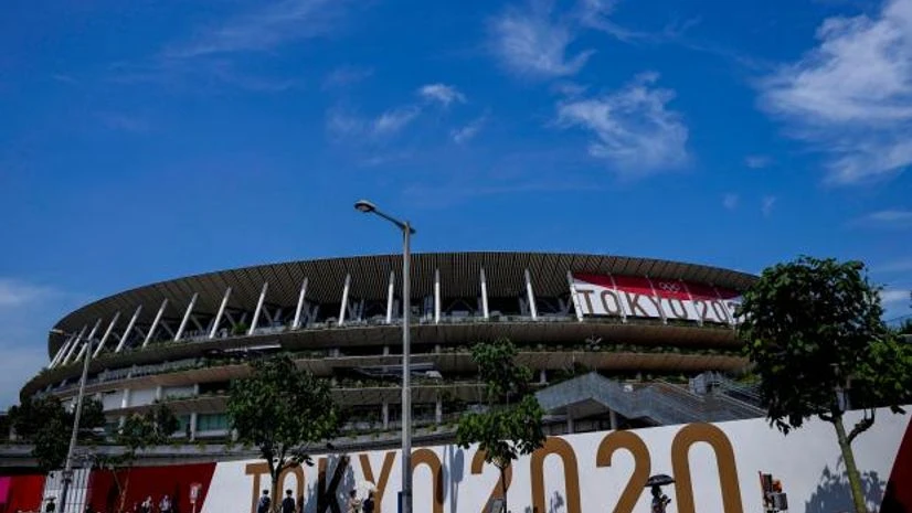 tokyo olympics People wearing a protective masks pass by National Stadium, where the opening ceremony of the Tokyo 2020 Olympics will be held in less than two weeks is seen in the background (Photo: AP/PTI)